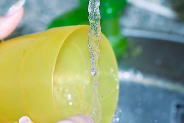 Image showing Female hands washing dishes close up photo