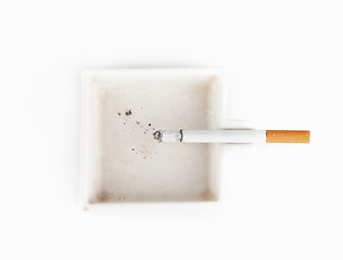 Image showing A burning cigarette in a white ashtray studio isolated on white