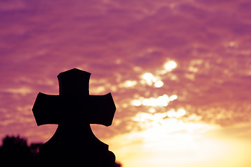 Image showing Silhouette of a church top with a cross a sunset in background