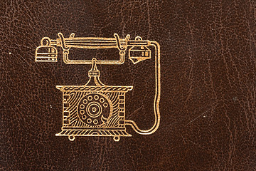 Image showing Old leather telephone book with golden telephone symbol