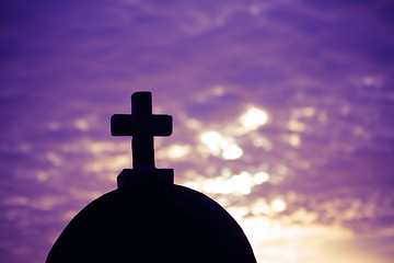 Image showing Silhouette of a church top with a cross a sunset in background