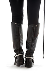 Image showing beautiful legs in black leather horseman boots with riding-crop