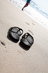 Image showing Flip flops on a sand beach