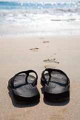 Image showing Flip flops on a sand beach