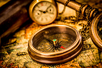 Image showing Vintage compass lies on an ancient world map.