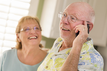 Image showing Senior Adult Husband on Cell Phone with Wife Behind