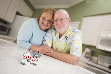 Image showing Senior Adult Couple Gazing Over Small Model Home on Counter