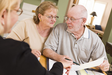 Image showing Senior Adult Couple Going Over Papers in Their Home with Agent