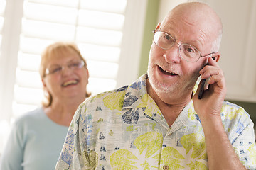 Image showing Senior Adult Husband on Cell Phone with Wife Behind