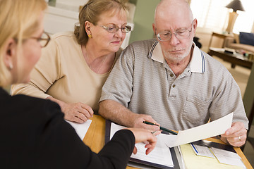 Image showing Senior Adult Couple Going Over Papers in Their Home with Agent