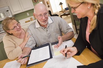 Image showing Senior Adult Couple Going Over Papers in Their Home with Agent