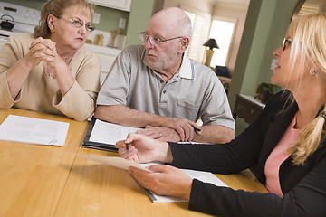 Image showing Senior Adult Couple Going Over Papers in Their Home with Agent