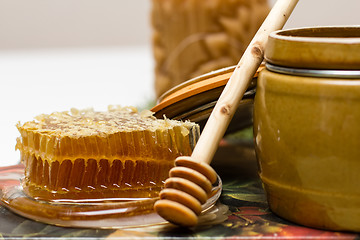 Image showing Honey in pot, honeycomb and stick