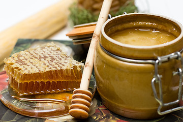 Image showing Honey in pot, honeycomb and stick