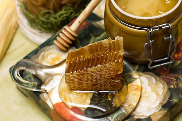 Image showing Honey in pot, honeycomb and stick