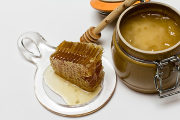 Image showing Honey in pot, honeycomb and stick