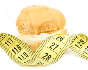 Image showing concept of slimming, caramel cake with measuring tape