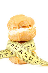 Image showing concept of slimming, caramel cakes with measuring tape