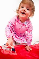 Image showing little, blond hair girl ironing