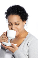 Image showing Dark skinned lady enjoys her coffee