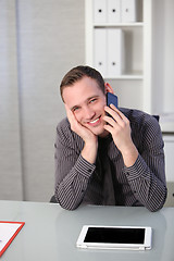 Image showing Business man using a mobile at his desk