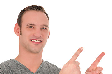 Image showing Smiling young man pointing upwards