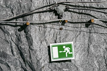 Image showing Green exit sign on cave wall