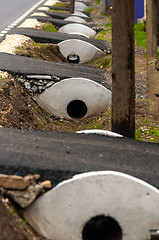 Image showing Sewage pipes under small road