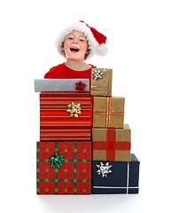 Image showing Young boy laughing behind gifts