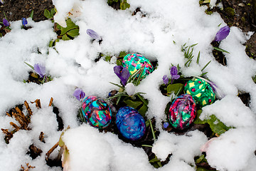 Image showing Colorful Easter eggs in snowy garden
