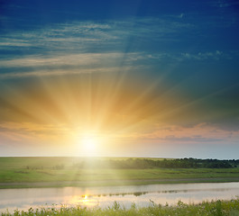 Image showing sunset over field and river