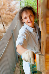 Image showing Pretty woman painting her house