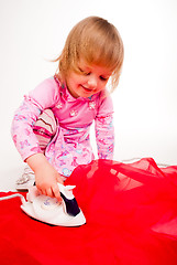 Image showing little, blond hair girl ironing