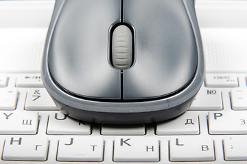 Image showing A wireless mouse placed on laptop keyboard
