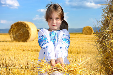 Image showing small rural girl on harvest field with straw bales