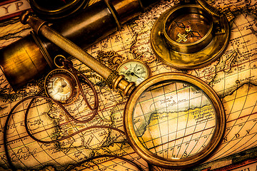 Image showing Vintage magnifying glass lies on an ancient world map