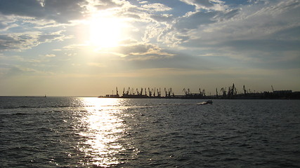 Image showing everning sea with hoisting crane in the seaport