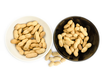 Image showing Black and white bowls full of peanuts on a white background