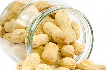 Image showing Close up of a glass jar full of unpeeled peanuts on a white back
