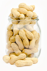 Image showing A jar full of unpeeled peanuts on a white background