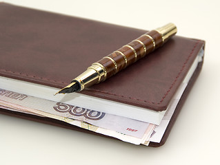 Image showing Money inside the diary, and pen