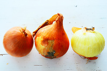 Image showing three onions on a white table