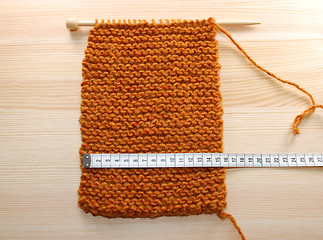 Image showing A length of knitting being measured in centimetres