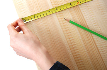 Image showing Using a steel tape measure on a wooden board 