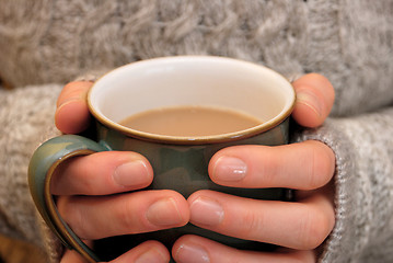 Image showing Two hands keeping warm, holding a hot cup of tea or coffee