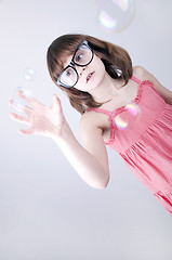 Image showing child with nerd glasses plaing with soap bubbles