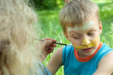 Image showing portrait of a child with his face being painted