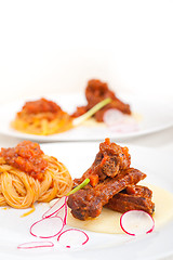 Image showing pasta with pork ribbs sauce on polenta bed