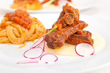 Image showing pasta with pork ribbs sauce on polenta bed