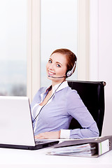 Image showing smiling young female callcenter agent with headset